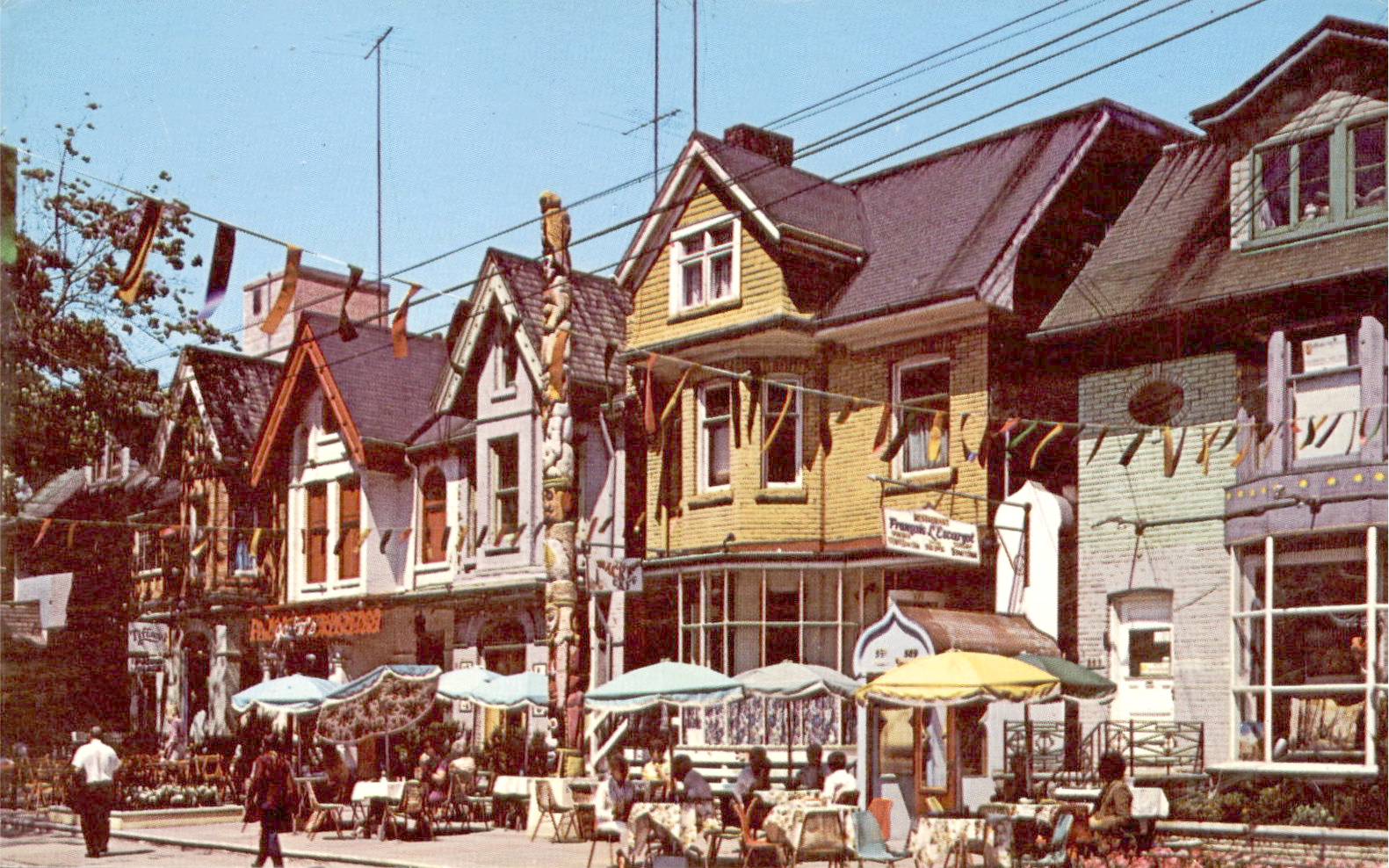 xx postcard - toronto - markham street village - shops and people eating outside in front of restaurants -totem pole - late 1960s